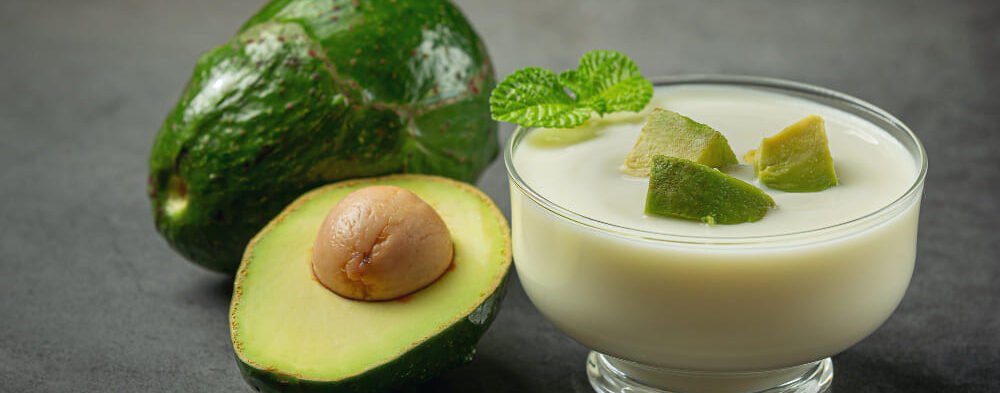 Healthy white drink behind Avocado fruits